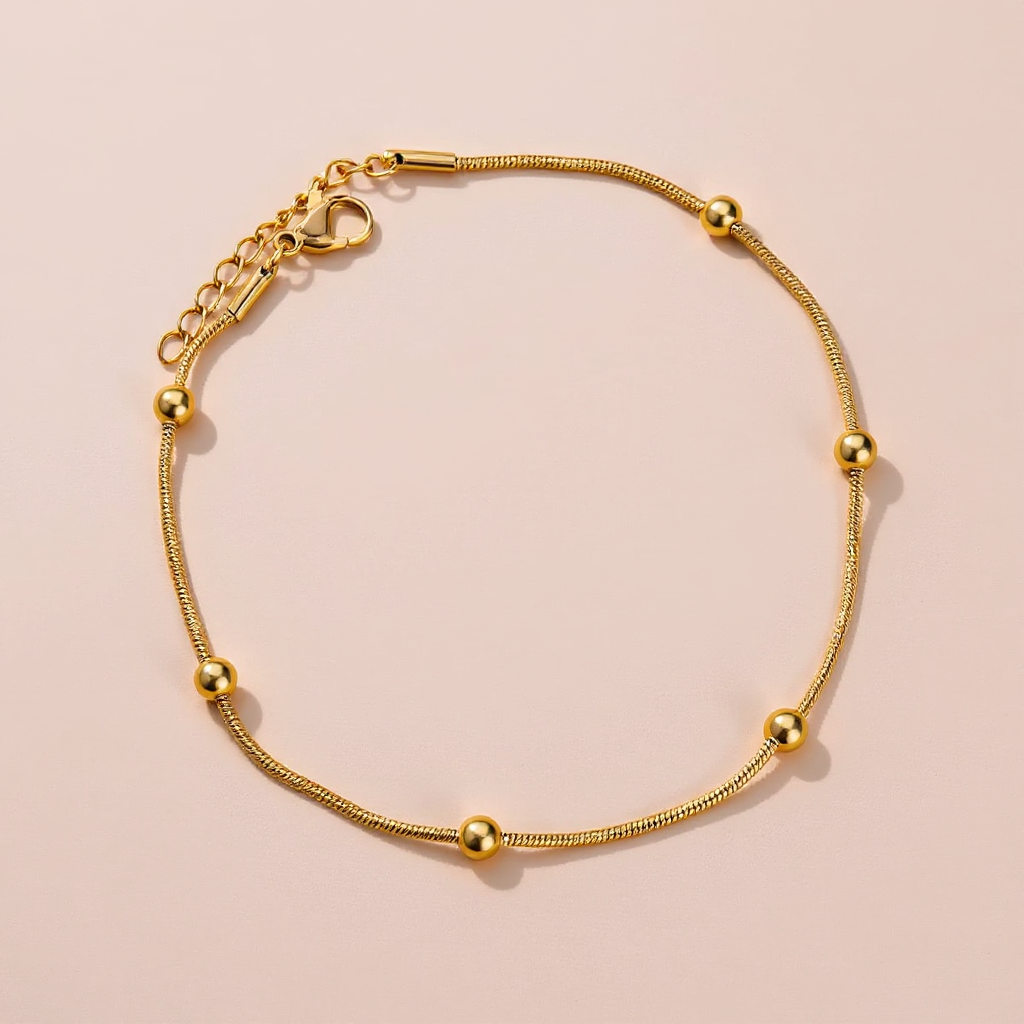 Gold Anklet with gold beads on a beige background