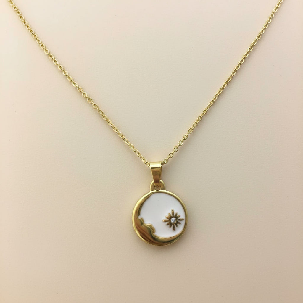 Gold necklace with a round pendant on a beige background