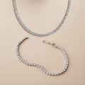 Tennis necklace and bracelet set on a beige background