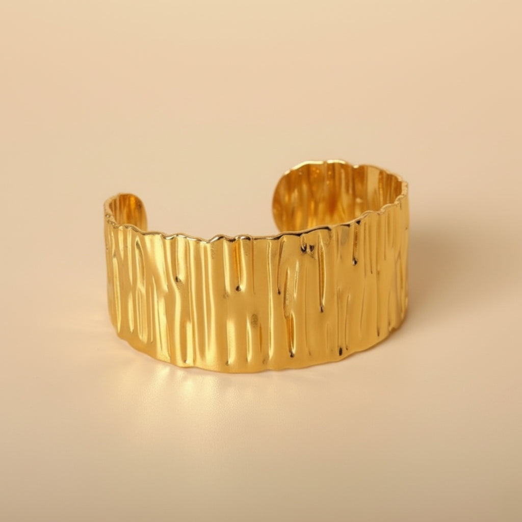 Gold bangle on a beige background