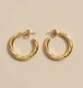 Gold hoop earrings on a beige background