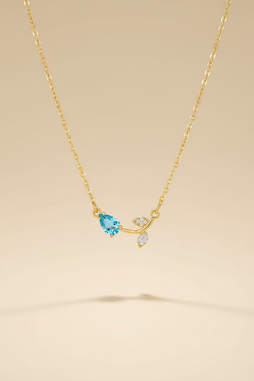 Gold necklace with a blue gemstone on a beige background
