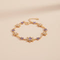 Gold bracelet with purple stones on a beige background