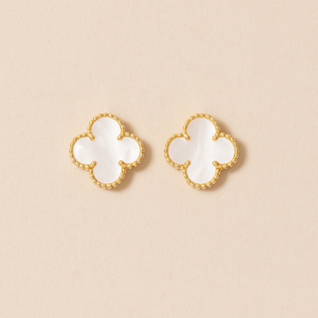 Pair of white Clover earrings on a beige background