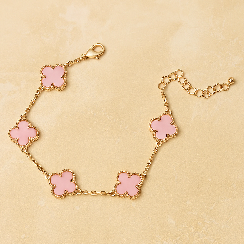 Gold bracelet with pink clover-shaped charms on a beige background