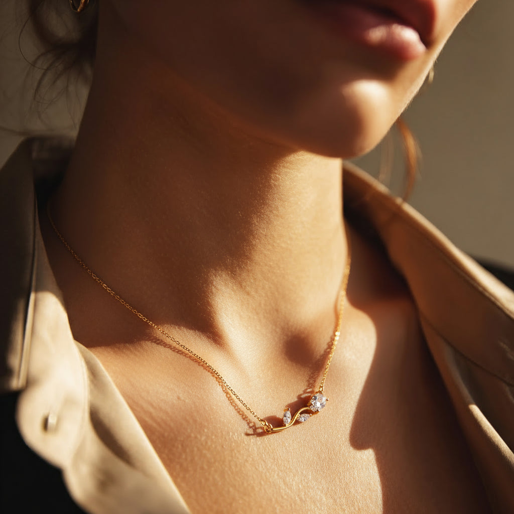 Close-up of a person wearing a gold necklace with a subtle design.